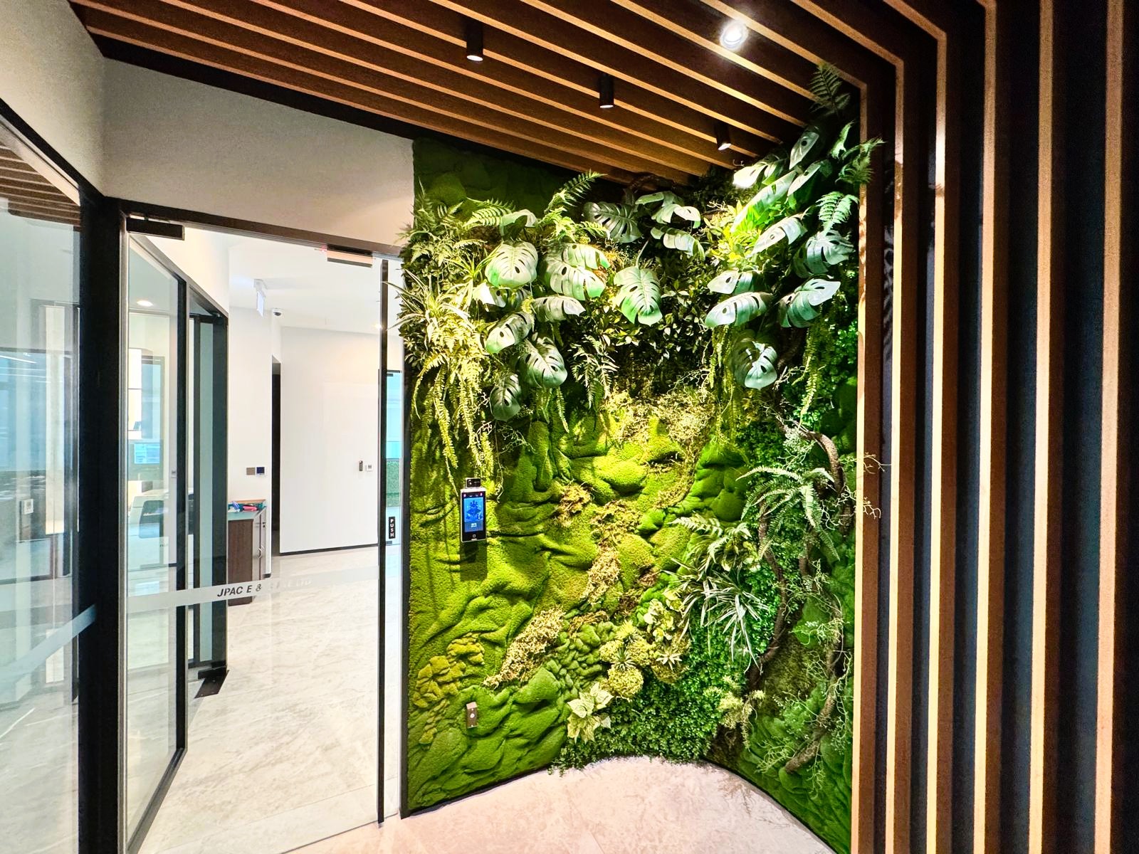 Modern office entrance featuring a vertical green wall with lush indoor plants – JPAC E & C Singapore interior and renovation project. Modern office entrance featuring a vertical green wall with lush indoor plants – JPAC E & C Singapore interior and renovation project.